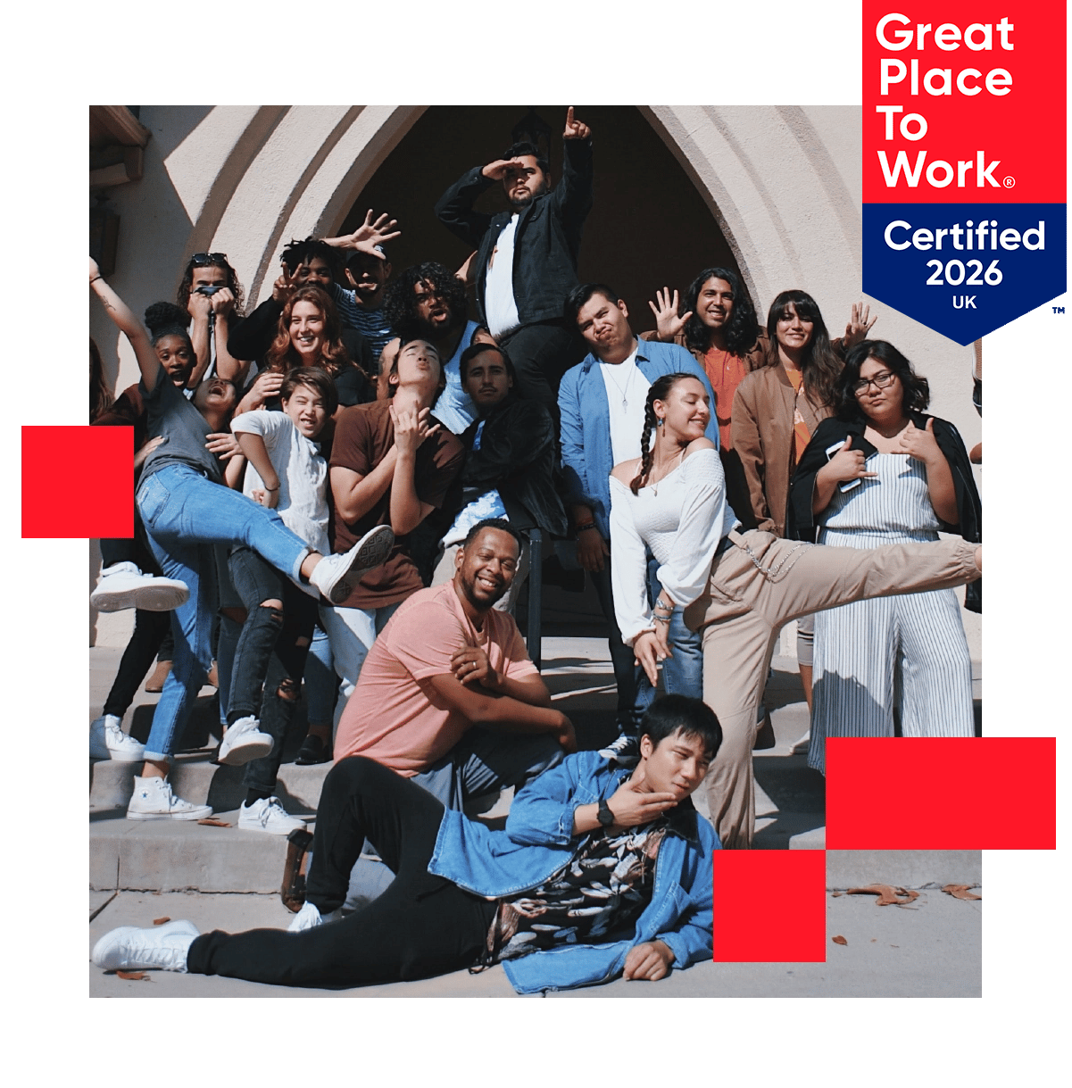 A group of employees posing for a photo looking happy and celebratory