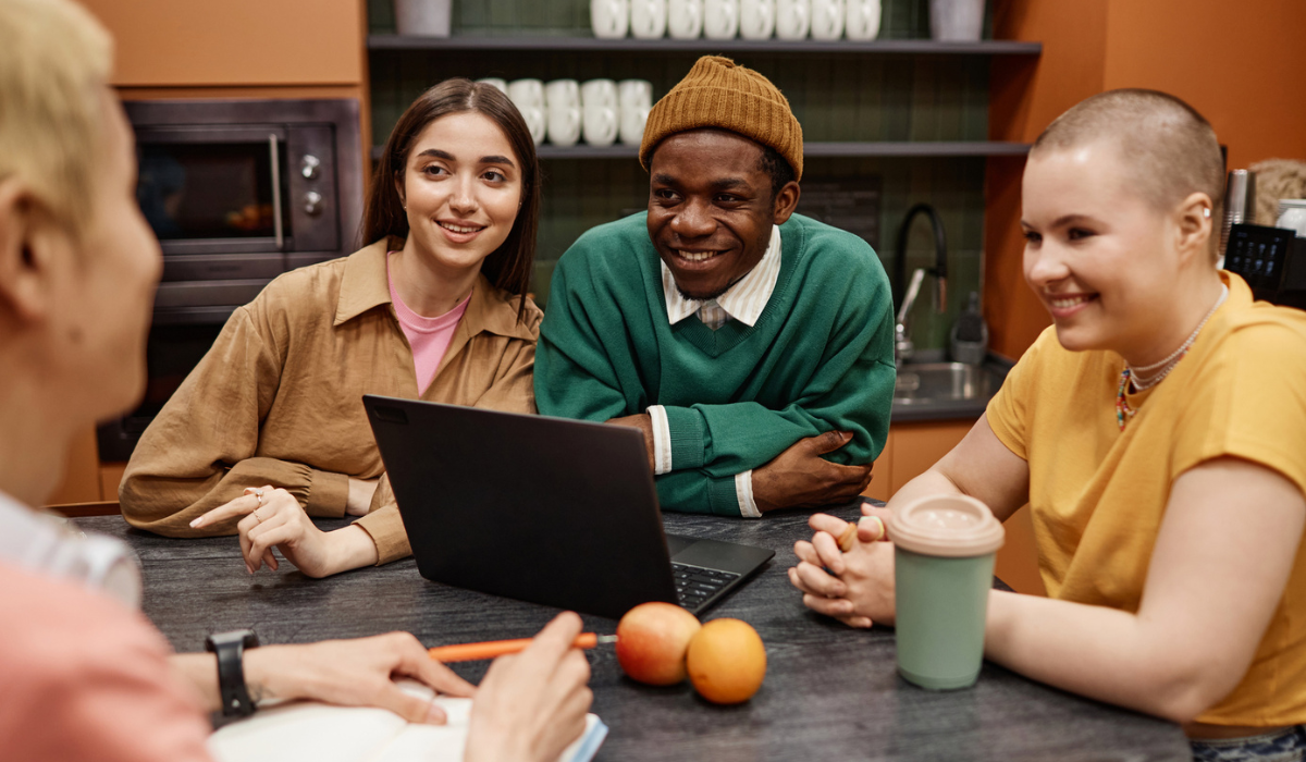Employees gathered around table talking and smiling