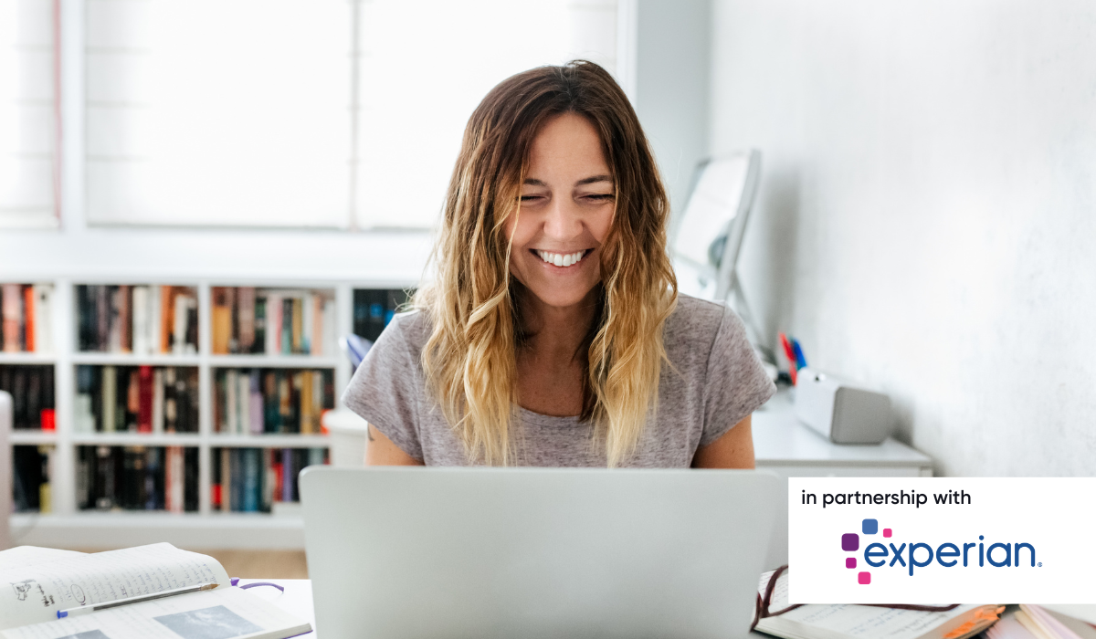 Woman working from home smiling at laptop